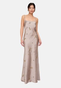 Langes Kleid mit Spaghettiträgern aus helltaupefarbenem Satin, verziert mit filigraner Goldstickerei und Perlen. Eine taillierte Silhouette mit einem fließenden Rock.