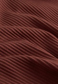 Material texturat de culoare roșu închis-maro cu model vertical în relief, prezentând pliuri moi și ondulate și o textură netedă.