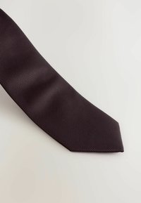 Cravate marron foncé avec un motif de rayures diagonales texturé et une pointe, fabriquée en tissu tissé.