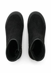 Mustat nilkkurit, jotka on valmistettu pehmeästä mokasta, jossa on tekstuuriset kumipohjat, pyöristetyt varpaat ja vetoketjut sivuilla. Sileä sisäpinta.