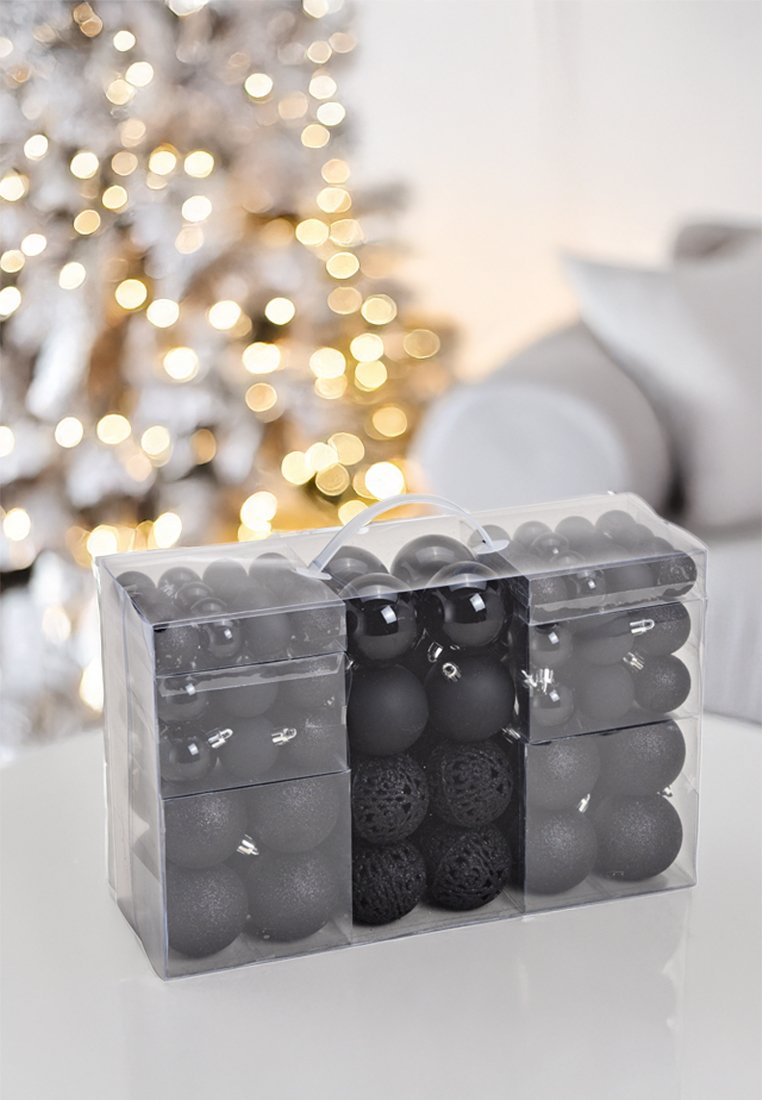 Czarny zestaw ozdób choinkowych w przezroczystym plastikowym pudełku, zawierający różne kształty i faktury, w tym matowe, błyszczące i dekoracyjne wzory.