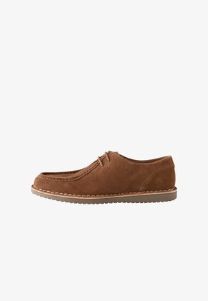 Brown suede lace-up casual shoe with moc toe stitching and beige rubber sole, shown from the side on a white background.