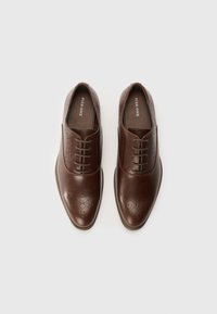 Brown leather dress shoes with a smooth finish, pointed toe, perforated detailing, and lace-up closure.  Simple design, no visible accents.