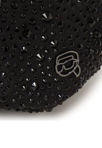 Sac en tissu noir orné de strass noirs de différentes tailles ; présente un accent logo argenté. Texture lisse avec des embellissements denses.