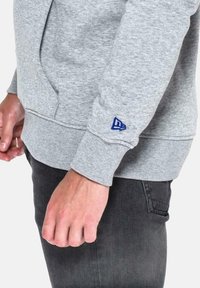 New Era Jersey con capucha - grau