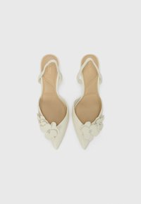 Chaussures slingback à bout pointu en cuir blanc cassé, ornées d'embellissements floraux avec des accents en strass sur le dessus. Semelle plate.