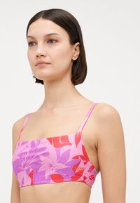 Bikini z kwiatowym wzorem, z kwadratowym dekoltem, cienkimi ramiączkami oraz kolorami różowym, fioletowym i czerwonym, wykonany z gładkiego, elastycznego materiału.