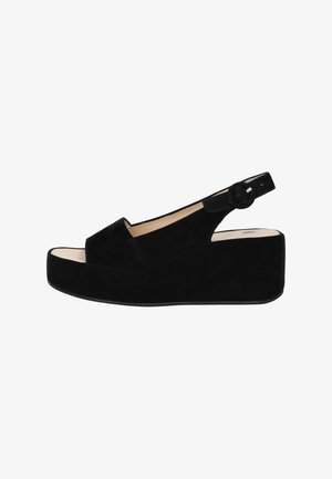 Sandalias de cuña de ante negras con una correa y un cierre de botón redondo, que presentan una punta descubierta y una suela lisa y gruesa.