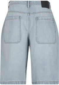 Shorts en denim bleu clair avec une coupe décontractée, dotés de deux poches arrière et d'un patch logo noir sur la taille.