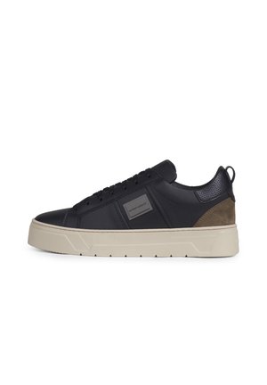 Zwarte lage sneaker met beige dikke zool, veterdesign, gestructureerde hielpatch en vierkant merklogo op het zijpaneel.