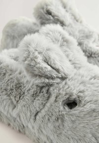 Graue Plüsch-Bunny-Schuhe zeichnen sich durch eine flauschige Textur, eine abgerundete Form und auffällige Ohren aus. Bemerkenswerte Details sind der weiche Stoff und die Nähakzente.
