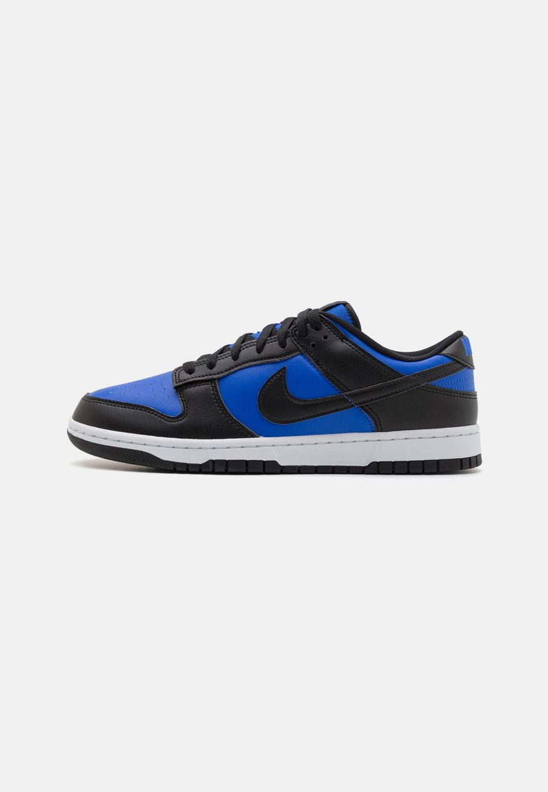 Sort og blå sneaker med en glat læderoverdel, tekstureret tå, hvid mellemsål og sort ydersål. Udstyret med Nike-logo i sort.