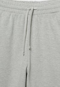 Szare bawełniane spodnie dresowe z elastycznym pasem i sznurkiem do regulacji. Miękka tekstura o gładkim wykończeniu, bez widocznych wzorów czy ozdób.