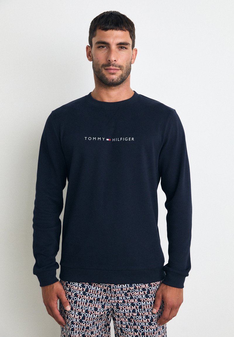 Marine genser med rund hals og lange ermer, med sentralt hvitt "TOMMY HILFIGER"-logo. Myk tekstur, uformell passform.