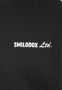 Tessuto di felpa nera con una superficie liscia e collo a costine; presenta il logo testuale bianco "SMILODOX Ltd." centrato sul petto.