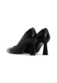 Scarpe nere in pelle con tacco alto, punta affusolata e un design del tacco curvo distintivo. Texture liscia con dettagli minimi.