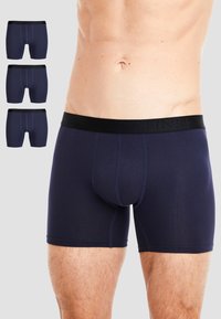Dark navy boxer briefs with a black waistband featuring the brand name. Material is smooth with a fitted design and subtle seam detailing.