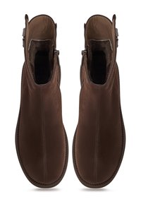 Un paio di stivali alla caviglia in suede marrone con zip laterale e fodera in pelle, mostrati in vista dall'alto su uno sfondo bianco.