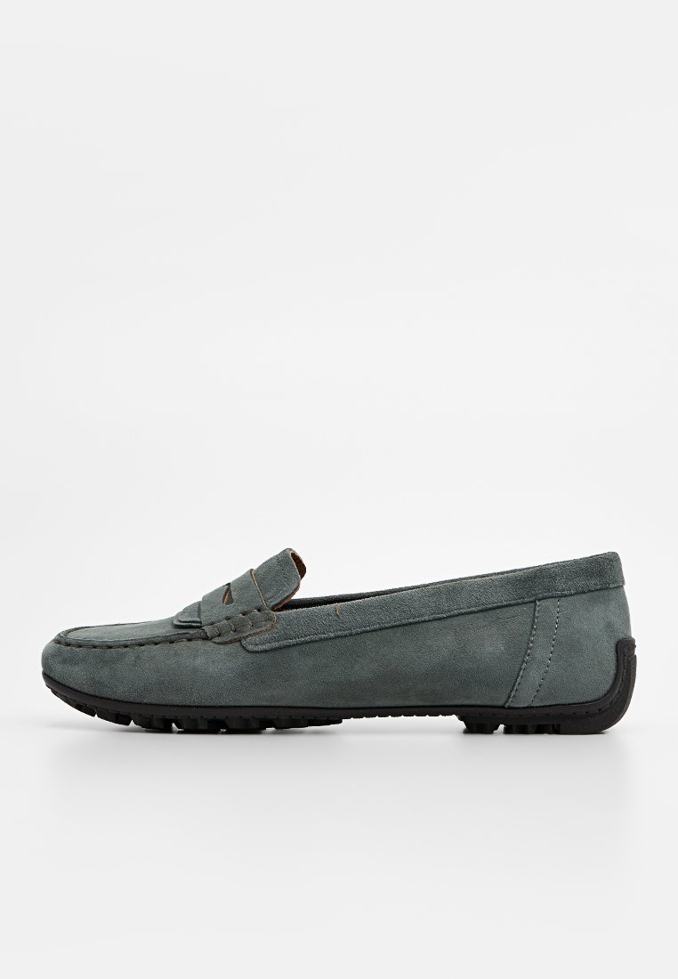 Mocassins en daim gris, avec un bout cousu, une sangle décorative et une semelle en caoutchouc noir texturé pour une meilleure adhérence et durabilité.