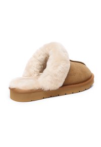 Tan suede slipper with a plush beige fur lining, open back design, and a textured rubber sole for grip. Soft texture and rounded shape.