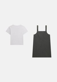 T-shirt bianco a maniche corte accanto a un vestito a righe grigio scuro con spalline regolabili e dettagli metallici.