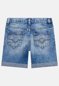 Jeansshorts i ljusblått med vikta fållar, som har två bakfickor och en triangulär logotypapplikation nära den högra fickan.