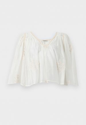 Blouse blanche à manches longues avec bordure en dentelle et broderie florale, dotée d'une coupe ample et d'un col froncé.