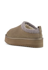 Semišové slip-on topánky v béžovej farbe s jemným, štruktúrovaným šedým podšívkou, so silnou, ryhovanou podrážkou pre lepšiu priľnavosť a ťahacou pútkom na zadnej strane.
