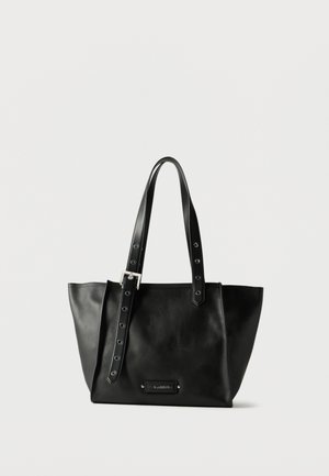 Borsa a tracolla in pelle nera con cinghia regolabile con fibbia e piastra con logo in metallo sul davanti su sfondo bianco.