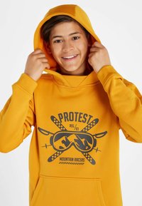 Felpa gialla con cappuccio e stampa grafica di occhiali protettivi e montagne. Presenta una tasca a canguro e polsini a costine per una vestibilità aderente.