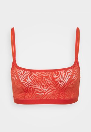 Sutiã vermelho com estampa de zebra, feito de material em renda. Apresenta alças ajustáveis e uma faixa elástica para conforto. Sem aro.