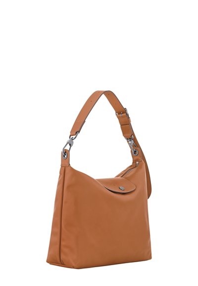 Hellbraune Lederschultertasche mit geschwungenem Design, silberner Hardware und verstellbarem Riemen. Verfügt über einen Druckknopfverschluss und eine glatte Textur.