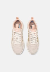 Sneaker rosa chiaro e crema in materiali mesh e suede. Presentano lacci bianchi, un motivo testurizzato sul lato e un logo sulla linguetta.