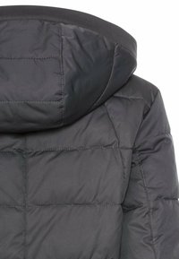 Zwarte pufferjas met capuchon, een gevoerde uitstraling en glad, waterafstotend materiaal met ribbeltrim rond de halslijn.