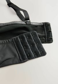 Zwarte bh met verstelbare bandjes, mesh stof aan de bovenkant en een haak- en oogsluiting met meerdere rijen voor grootte-aanpassing.