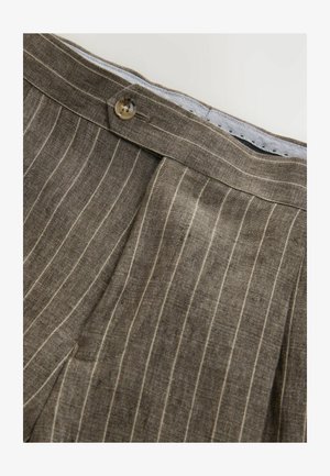 Pruunist linane püksid, millel on vertikaalsed valged triibud, nööp sulgemisega ja tekstureeritud kangas. Servad on hoolikalt viimistletud.