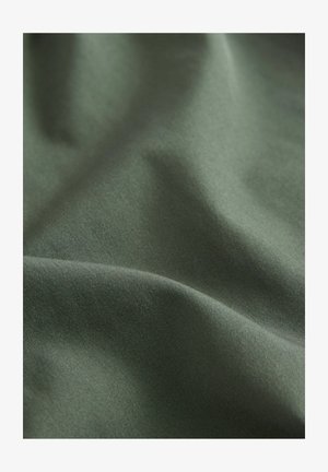 Échantillon de tissu en vert foncé, texture lisse avec une légère brillance, présentant de doux plis et des variations subtiles de couleur et de lumière.