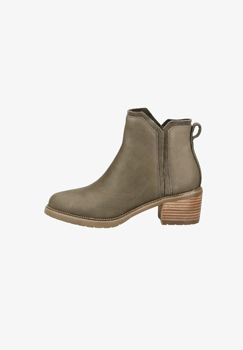 Bottine en daim taupe avec talon carré empilé, languette de tirage et panneaux latéraux élastiques pour un enfilage facile.