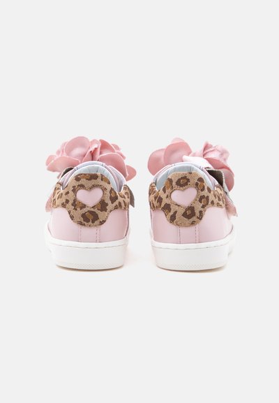 Baskets roses pour enfants avec des patchs de talon imprimés léopard comportant des découpes en forme de cœur et de grandes décorations de fleurs en tissu rose sur le dessus.