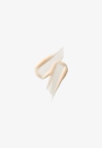 Deux traces de crème beige avec une texture douce sur fond blanc, montrant une consistance lisse et légèrement brillante du produit.