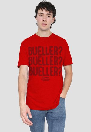 Red cotton t-shirt featuring bold black text with repeated "BUELLER?" and a subtitle "FERRIS BUELLER'S DAY OFF." Classic crew neck design.
