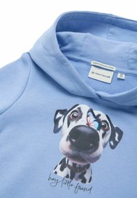Hoodie azzurro chiaro realizzato in cotone biologico, con una grafica di un Dalmata con una farfalla sul naso e il testo "hey piccolo amico".