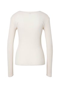 Chemise ajustée à manches longues couleur crème avec un col rond vue de dos sur fond blanc.