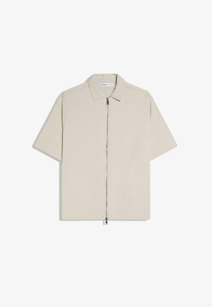 Bézs rövid ujjú ing gallérral és teljes hosszúságú elülső cipzáras záródással.