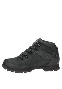 Zapatilla deportiva de caña alta en color negro que cuenta con un upper texturizado, cordones resistentes, suela de goma con tracción y talón reforzado para soporte.