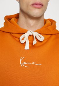 Karl Kani SMALL SIGNATURE HOODIE UNISEX - Camisola - cognac