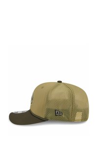 Casquette vert olive avec un dos en mesh, visière plate et détail de logo brodé. Elle présente un panneau avant uni et une texture à motif à l'arrière.