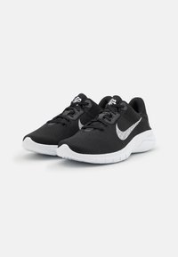 Scarpe sportive nere con una tomaia in rete traspirante, accenti bianchi, una suola ammortizzata e design con lacci. Logo prominente sul lato.