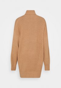 Tannfärgad stickad tröja med hög krage, ribbat mönster och långa ärmar, med en lös passform och en något förlängd bakre fåll.