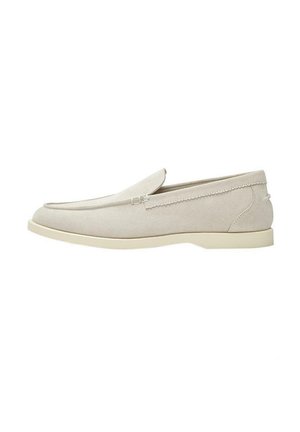 Mocassins en daim beige clair à enfiler, avec bout arrondi, petit talon et coutures simples le long des côtés et du bord supérieur.